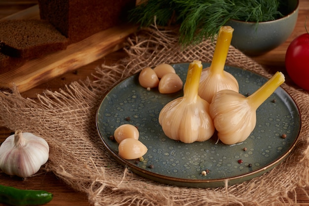 Ail blanc mariné sur une assiette sur un bois