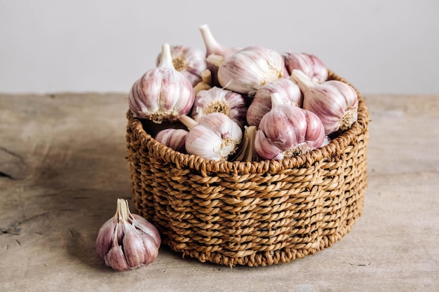 Ail dans un panier en osier sur un fond de table en bois