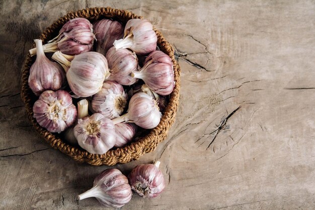 Ail dans un panier en osier sur un fond de table en bois