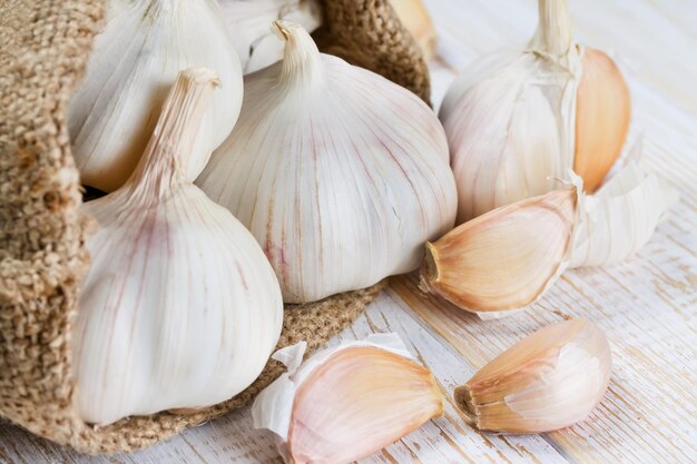 Ail dans un sac sur une vieille surface en bois