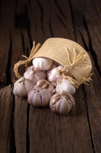 Ail frais et épices Ail dans le panier sur le vieux fond en bois