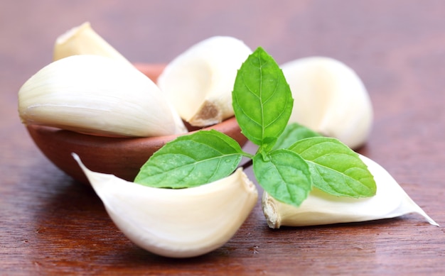 Ail frais avec des feuilles de menthe sur une surface en bois