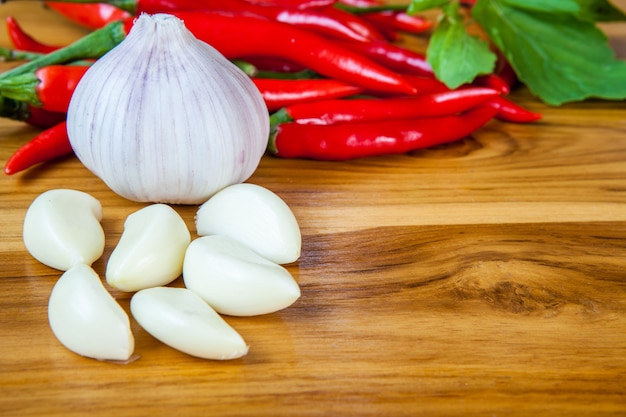 Ail frais et piment rouge sur un fond en bois.