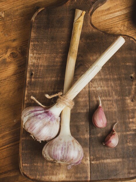 Ail sec sur une planche à découper en bois. ail frais comme moyen de perte de poids. nourriture saine.