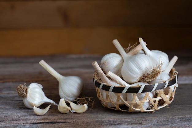 Ail sur une tasse en bois sur une table en bois.