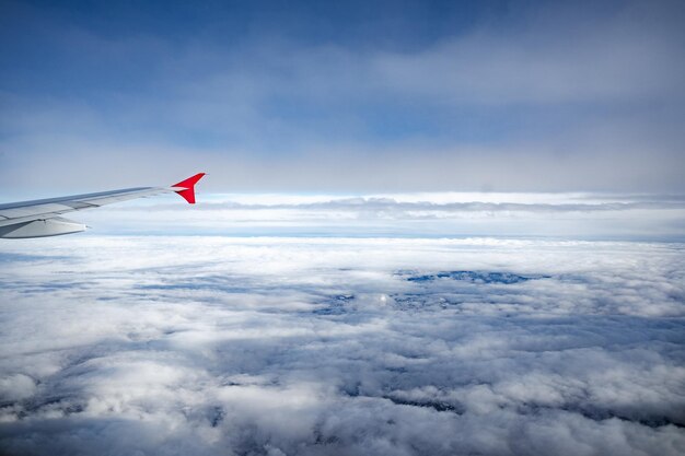 Aile d'avion au-dessus de beaux nuages et ciel bleu