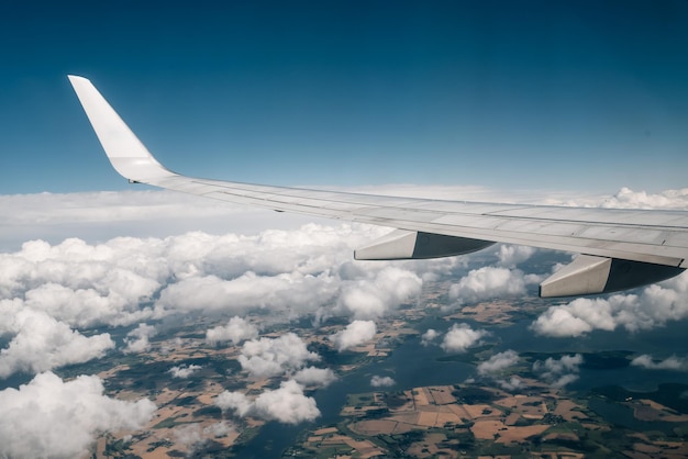 Aile d'avion au-dessus des nuages contre le ciel bleu