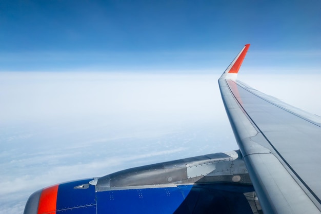 Aile d'avion avec ciel bleu clair et nuages blancs au-dessus du concept de voyage ou de vacances au sol d'été