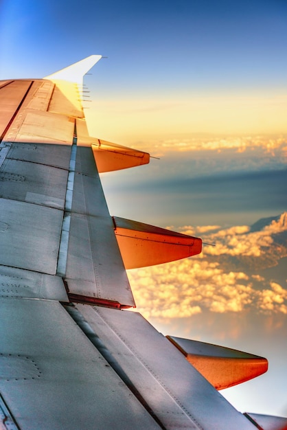 Photo aile d'avion contre le ciel au coucher du soleil