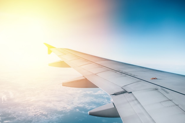 Aile d'avion avec lever de soleil en lumière flare