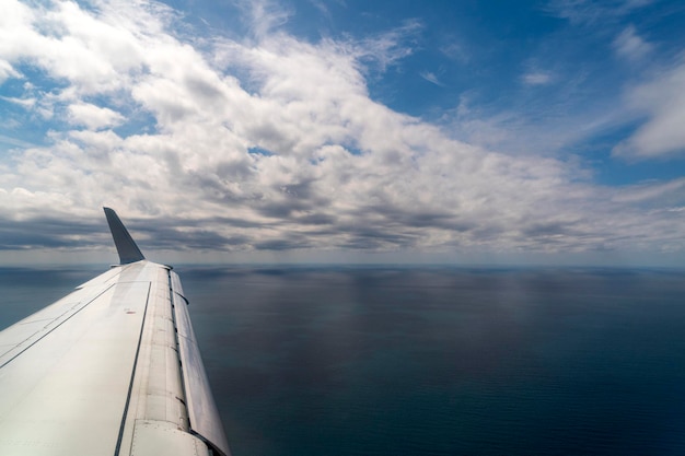 Aile d'avion lors de l'atterrissage survolant le fond de la mer