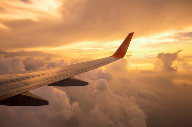 Aile d'avion sur les nuages du coucher de soleil