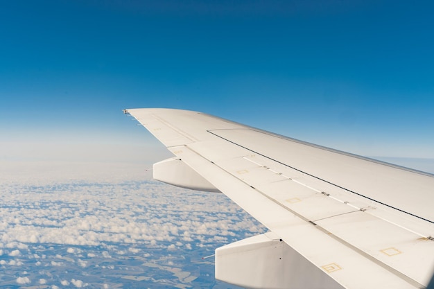 Aile d'avion de passagers au-dessus de la terre vue de l'intérieur