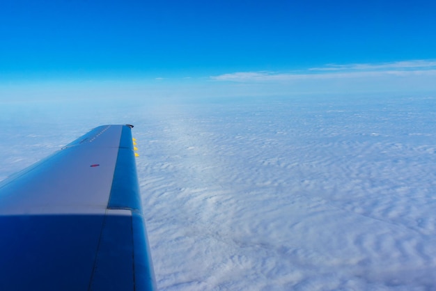 Aile d&#39;avion volant au-dessus des nuages ​​dans le ciel