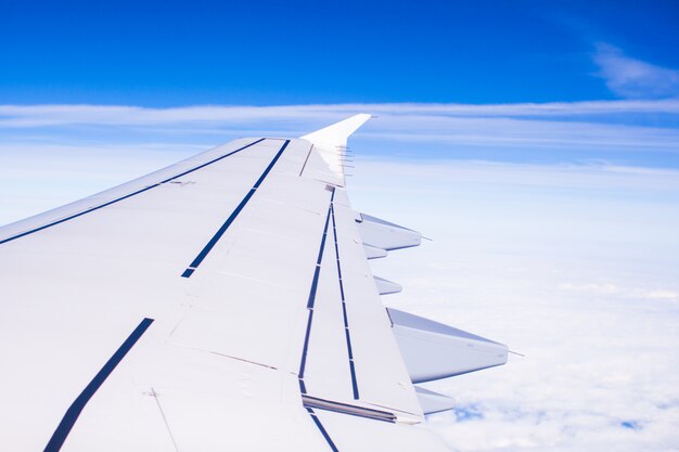 Aile d'un avion volant au-dessus des nuages