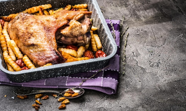 Aile de dinde frite avec frites dans une plaque à pâtisserie sur une serviette à carreaux