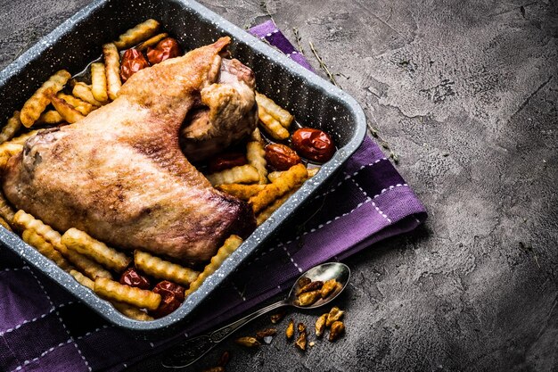 Aile de dinde avec frites dans une plaque de cuisson vue de dessus