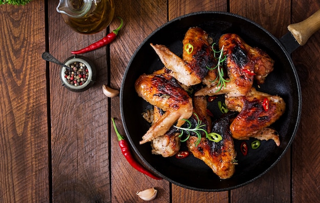 Ailes de poulet au four en pan sur table en bois.