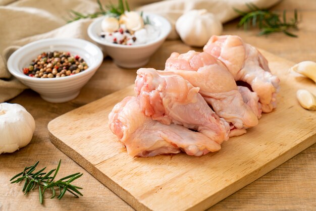 Ailes de poulet cru frais (drumette ou pilon) sur planche de bois