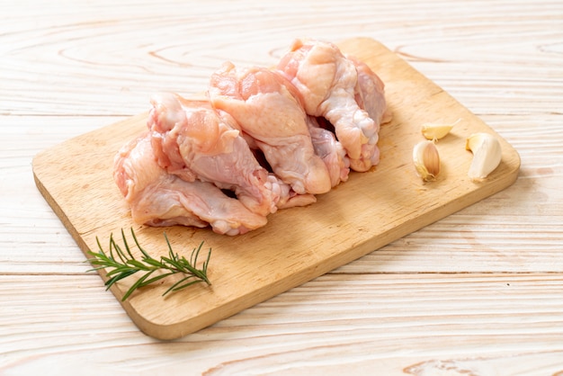 Ailes de poulet cru frais (drumette ou pilon) sur planche de bois