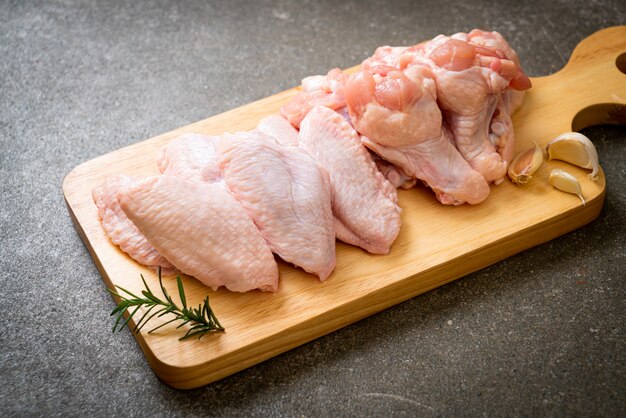 ailes de poulet cru frais sur planche de bois