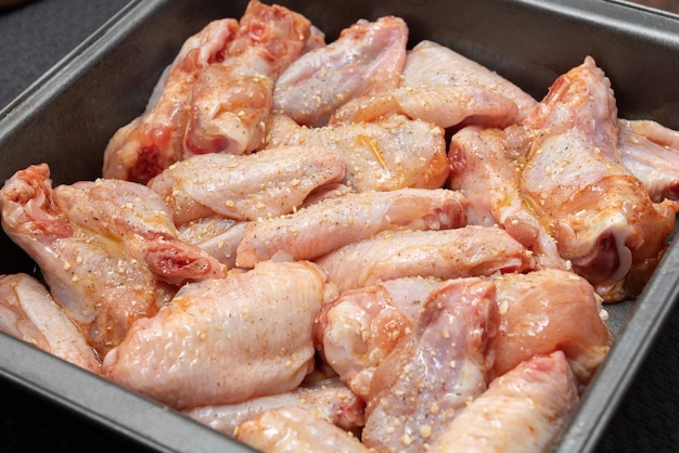 Ailes de poulet crues dans un bol non préparé avec des épices