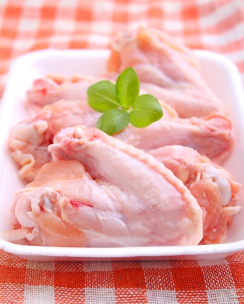 Ailes de poulet crues sur fond blanc