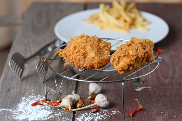 Ailes de poulet frites avec des frites sur une table en bois