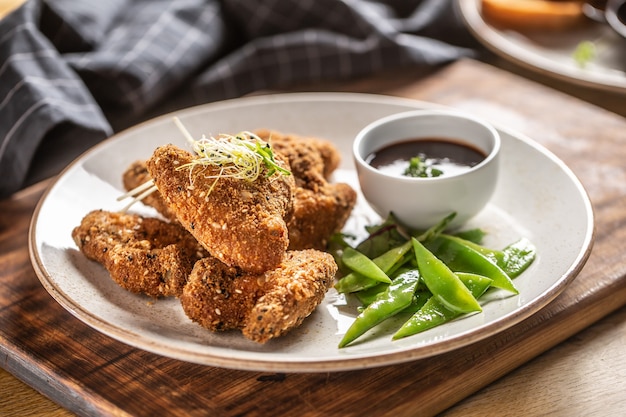 Ailes de poulet frites avec pois mange-tout et herbes.