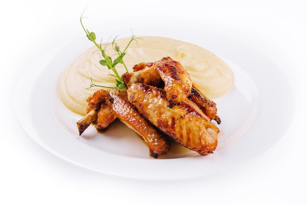 Ailes de poulet frites et purée de pommes de terre sur assiette