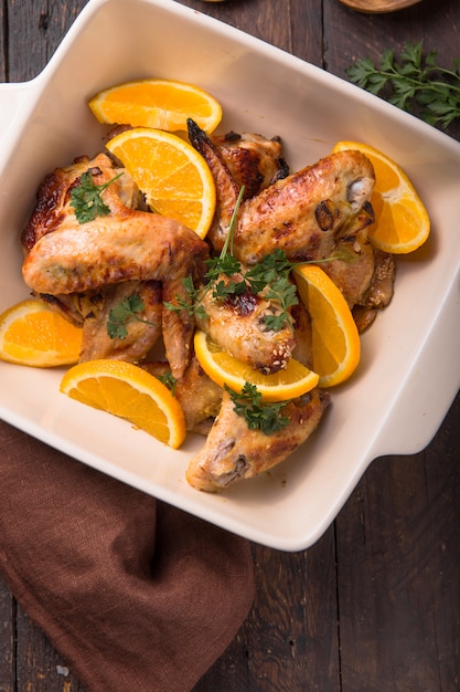 Ailes de poulet frites avec des tranches d'orange