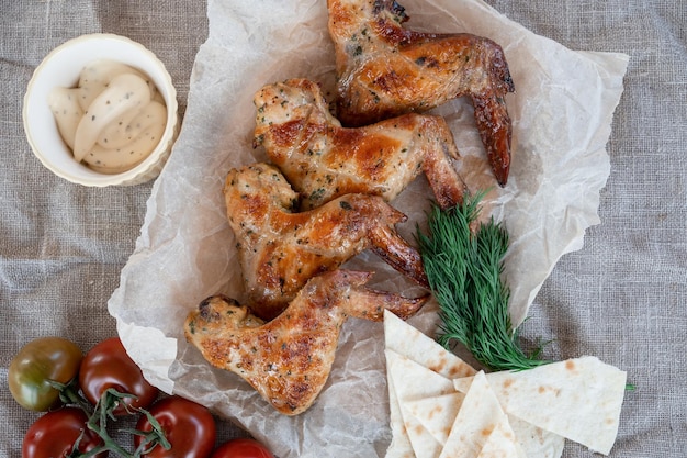 Ailes de poulet grillées épicées prêtes avec des légumes verts et concept de repos d'été à la tomate