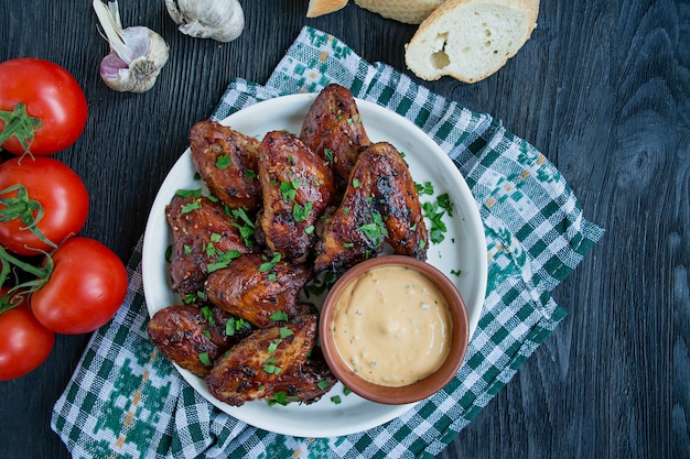 Ailes de poulet grillées avec sauce et herbes. Ailes de poulet cuites à la poêle.