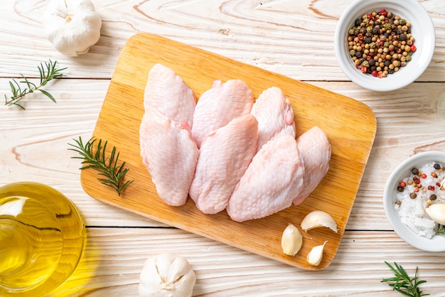 Ailes de poulet moyen cru frais sur planche de bois