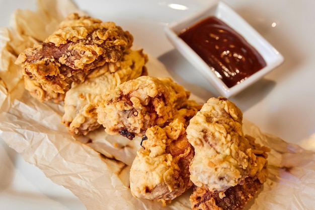 Ailes de poulet panées sur papier froissé avec sauce