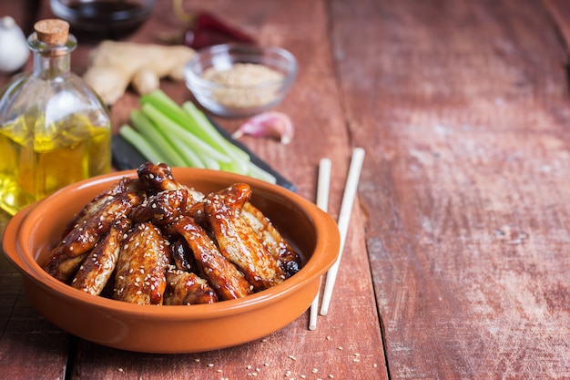 Ailes de poulet sautées asiatiques traditionnelles au sésame et légumes