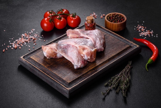 Les ailes de poulet se trouvent sur une planche de bois sur fond noir