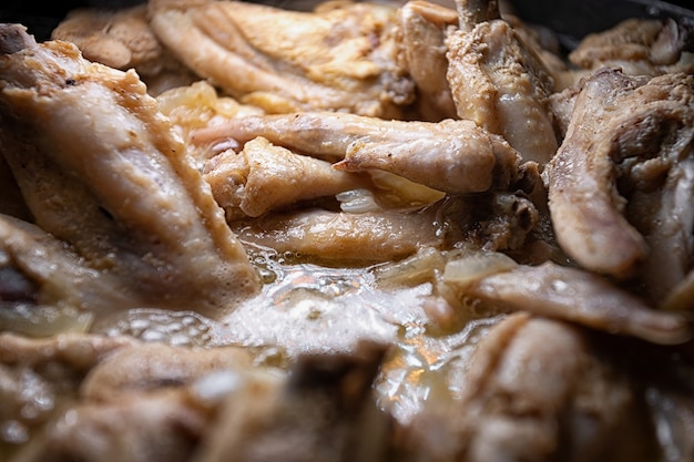 Les ailes de poulet sont cuites dans leur propre jus dans une casserole