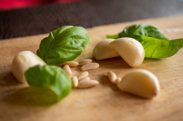 Ails, feuilles de basilic et pignons dans une table en bois