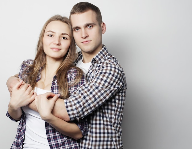 Aime la famille et les gens concept beau couple heureux étreignant sur fond gris