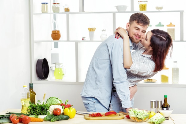 Aimer heureux couple préparer une salade saine de légumes frais dans la cuisine
