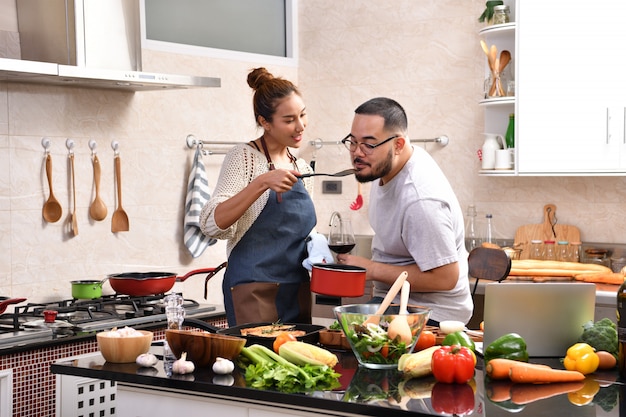 Aimer le jeune couple asiatique cuisiner dans la cuisine faire des aliments sains ensemble se sentir amusant