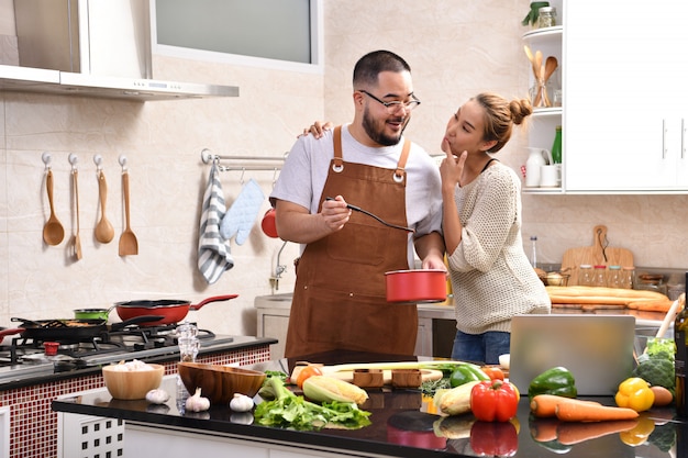 Aimer le jeune couple asiatique cuisiner dans la cuisine faire des aliments sains ensemble se sentir amusant