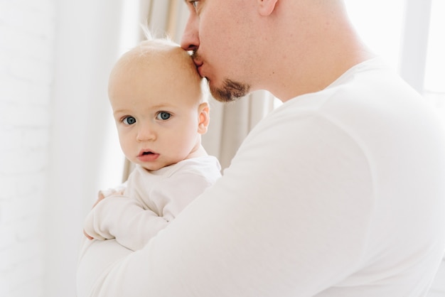 Aimer papa caucasien tenant et embrassant son petit bébé