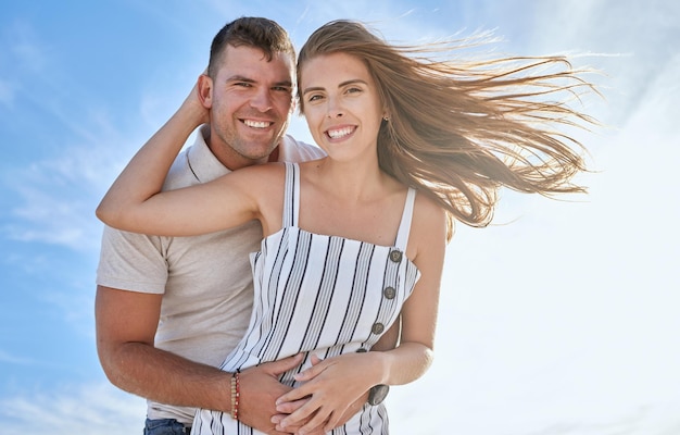 Aimez le ciel bleu et le portrait d'un couple câlin lors d'un rendez-vous romantique en plein air pour s'amuser ou pour la liberté de vacances