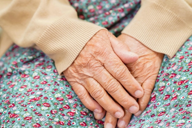 Aîné asiatique femme âgée patiente assise sur le lit à l'hôpital en gros plan à la main