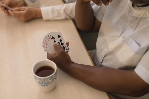 Photo un aîné joue aux cartes dans le salon.