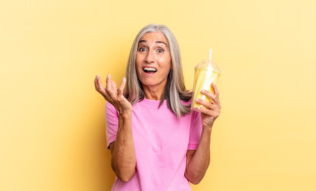 L'air désespéré et frustré, stressé, malheureux et agacé, criant et hurlant et tenant un milk-shake