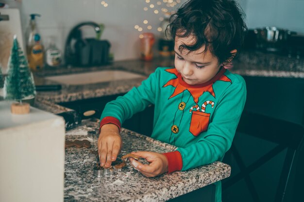 Photo l'air est rempli d'une atmosphère festive alors qu'une mère et son fils passent un bon moment à préparer du pain d'épice pour noël.