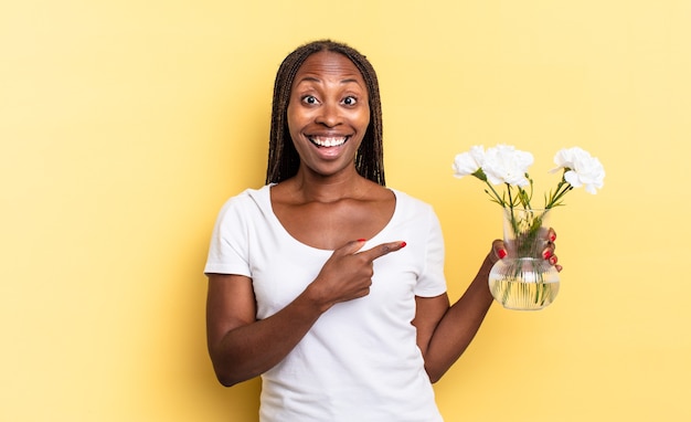 L'air Excité Et Surpris En Pointant Sur Le Côté Et Vers Le Haut Pour Copier L'espace. Concept De Fleurs Décoratives